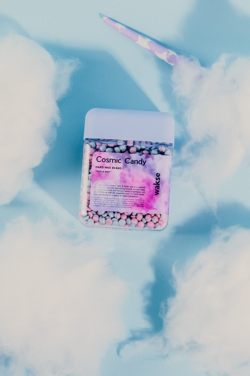 wakse Cosmic Candy sticks with a packet of cotton candy on a light blue background