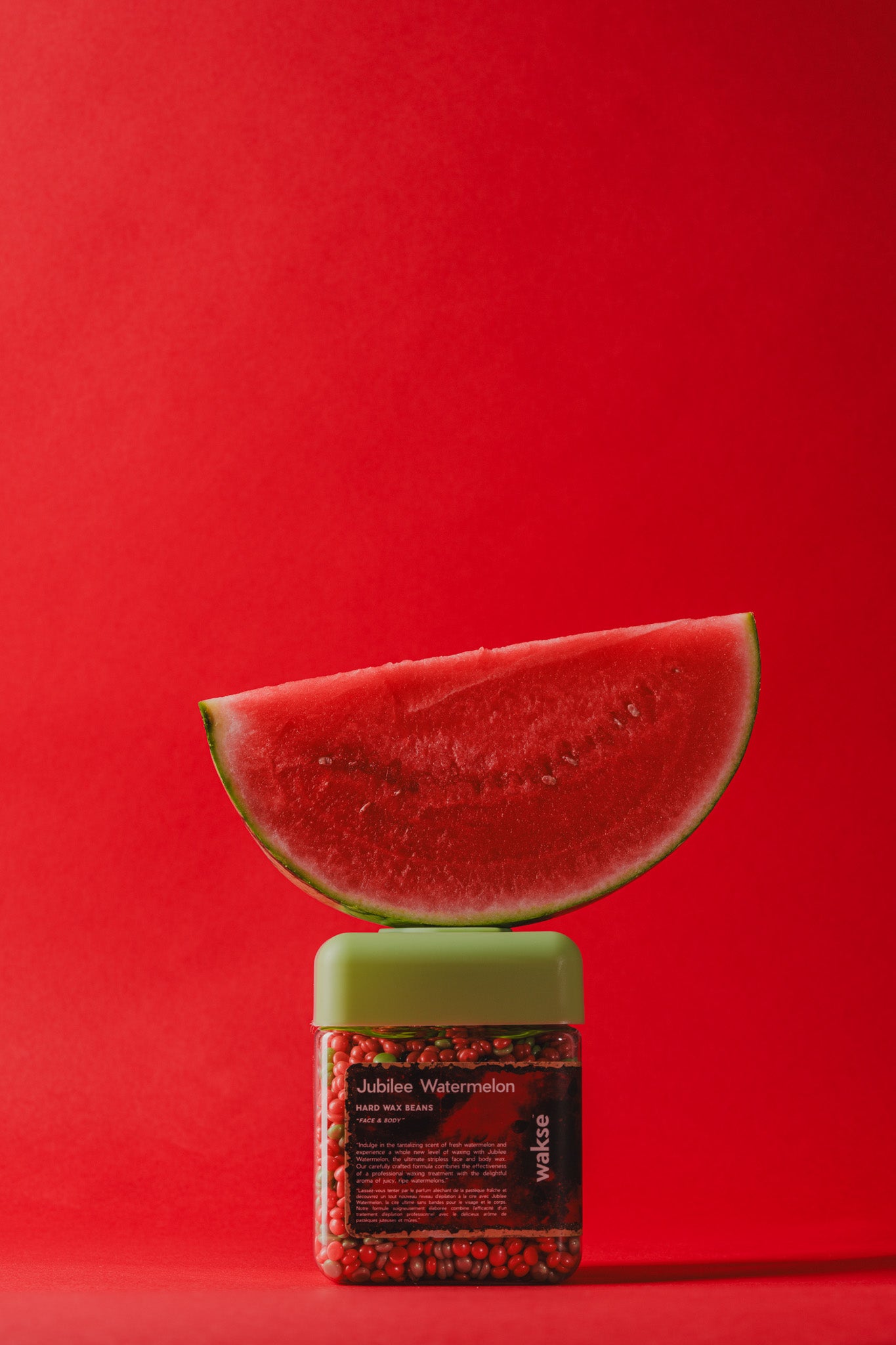 wakse Sliced watermelon on top of a container with a red background