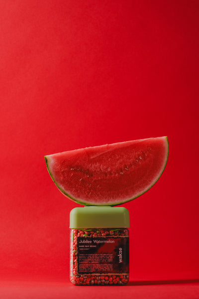 wakse Sliced watermelon on top of a container with a red background