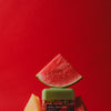 wakse Jar of watermelon-flavored product with watermelon slices on a red background