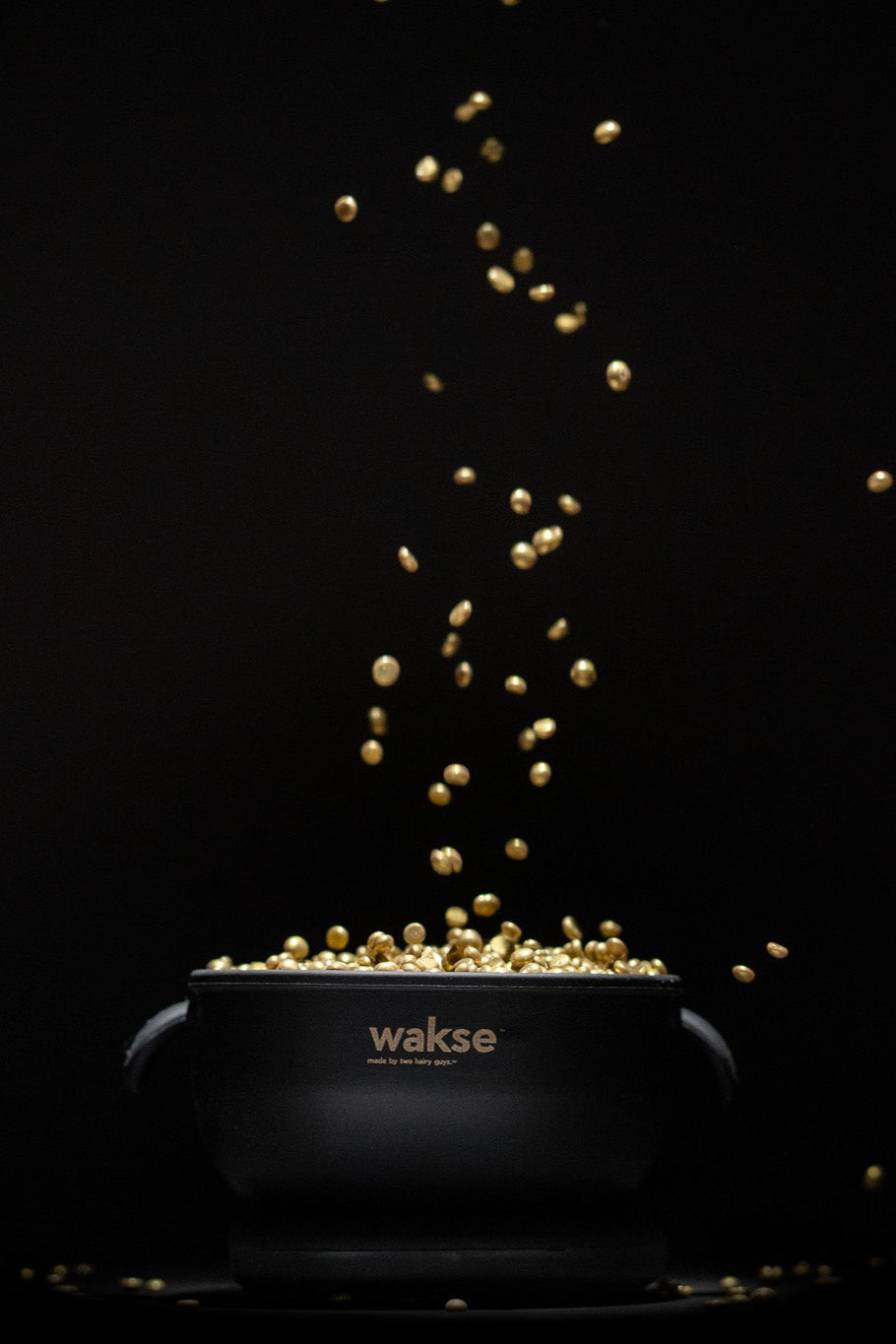 Electric wax warmer for hard wax black pot with gold wax beads falling inside