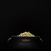 Black electric wax warmer for hard wax filled with golden wax beads on a dark background