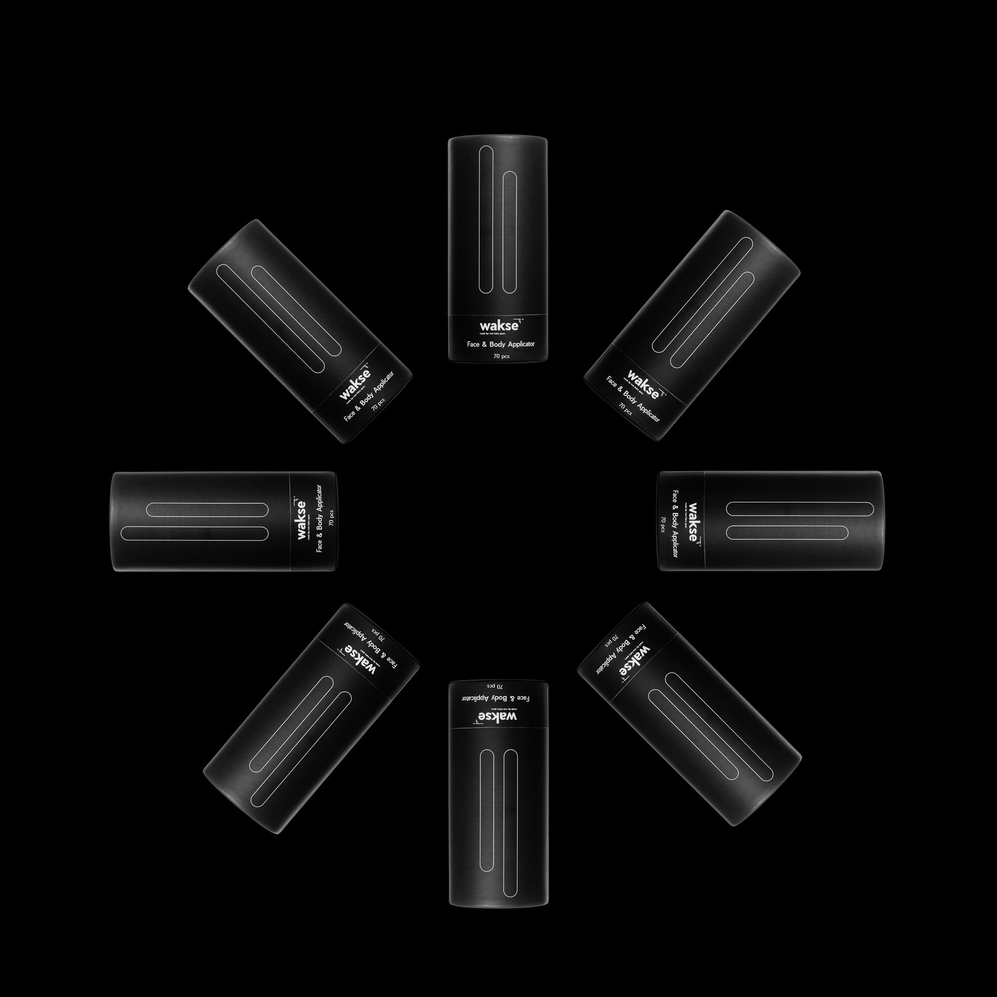 Black face and body wax applicator set arranged in a circular pattern on black background