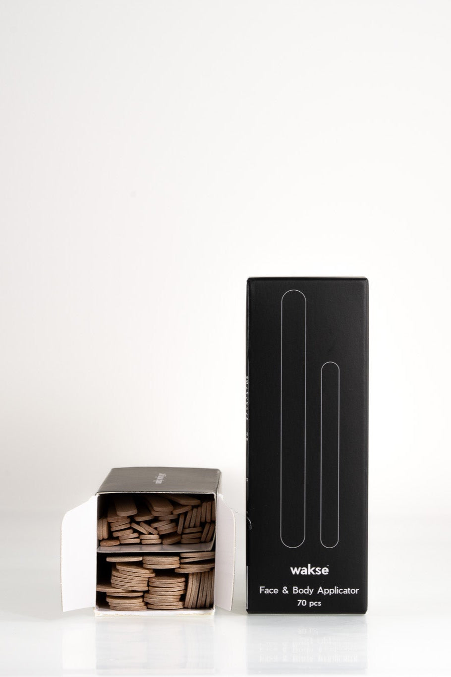 Black box and open white box with wooden sticks in face and body wax applicator set by Wakse